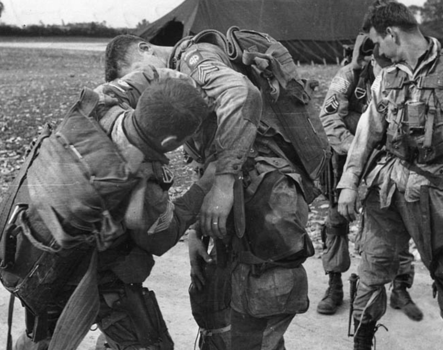 Men of the 82nd adjust gear before boarding their transports 